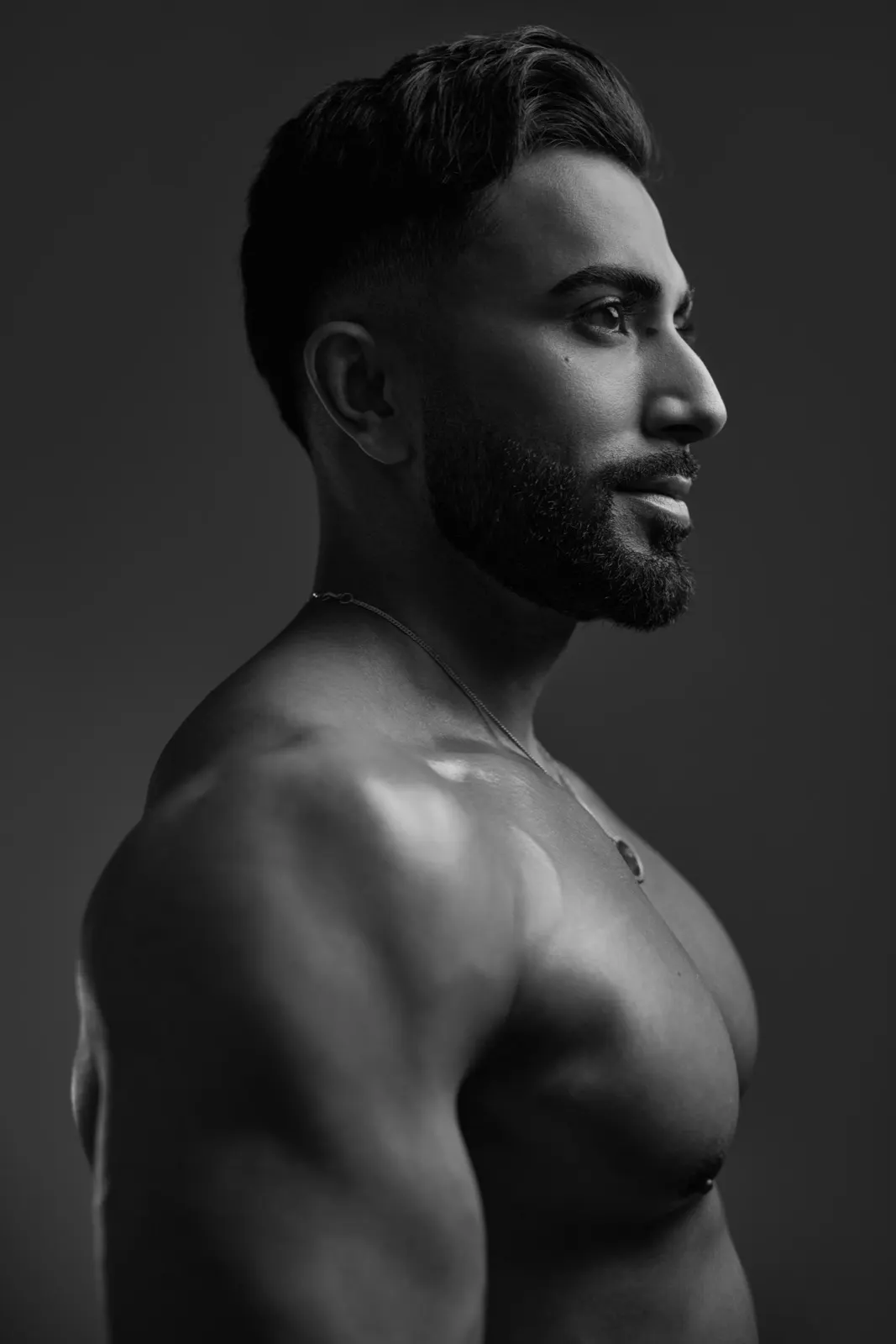 Hemel is shown in a close black-and-white side profile with dramatic lighting emphasizing his face, shoulder, and upper body.
